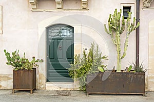 FaÃ§ade of typical town house with green cactuses and old door in a Mediterranean city Syracuse on Sicily, Italy