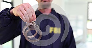 FBI officer holding handcuffs and arresting suspect