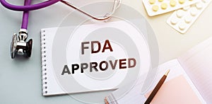 FDA approved - text on document with pills and stethoscope. Healthcare or medical concept
