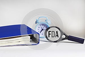 FDA concept. Concept of the Food and Drug Administration. Magnifier glass, folder and clock