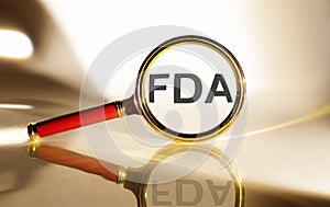 FDA concept. Magnifier glass with text on the white background in sunlight