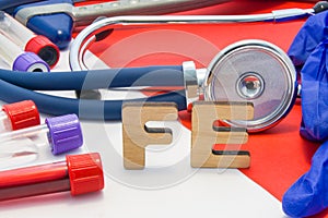 FE medical abbreviation meaning total iron or ferrum in blood in laboratory diagnostics on red background. Chemical name of FE is