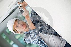 Feamle technician adjusting cctv camera on wall