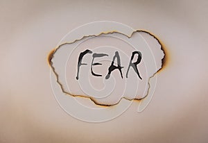 Fear concept, word on burnt paper