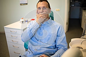 Fear Of Dentists. Phobia Dentist, Patient in the Dental Office. The young guy feels the fear of the dentist.