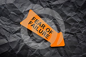 Fear of failure abstract. Crumpled paper and orange arrow.