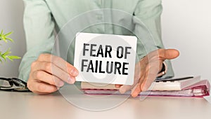 Fear Of Failure message on the card shown by a woman, Business Concept