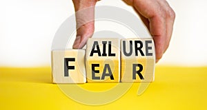 Fear of failure symbol. Businessman turns wooden cubes and changes the concept word Failure to Fear. Beautiful yellow table white