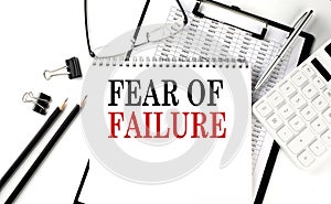 FEAR OF FAILURE word on notepad with clipboard , chart and calculator, business concept