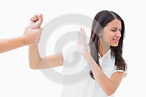 Fearful brunette being grabbed by the hand