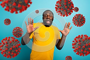 Fearful expression of a boy who is scared to catch the coronavirus. Cyan background. photo