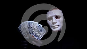 Fearful man in face mask looking at dollars in his hands, robbery, cyber attack