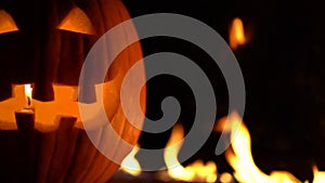 Fearful symbol of Halloween - Jack-o-lantern. Scary smiling head of pumpkin in inferno fire flames. Half of orange gourd