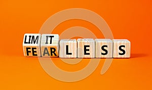 Fearless and limitless symbol. Concept word Fearless and limitless on wooden cubes. Beautiful orange table orange background.