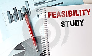 FEASIBILITY STUDY text on notebook on chart background