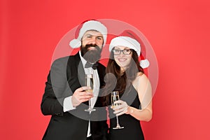 Feast of Christmas. tuxedo man with woman in santa hat. merry christmas and cheers everyone. business man and girl drink