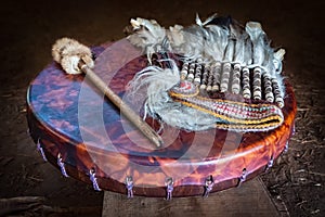 Feather headdress, ancient amerindian leather tambourine and drum drumstick. Attributes of the ancient american indian. photo