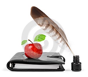 Feather in ink bottle and workbook with an Apple photo