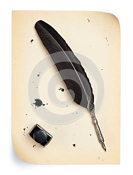 Feather quill and inkwell on an old paper photo