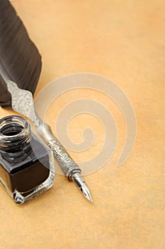 Feather quill and inkwell on an old paper