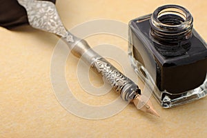 Feather quill and inkwell on an old paper