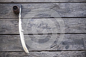 Feather for writing and inkwell .Quill for writing. The feather lies on an old wooden table with inkwell . Beautiful background