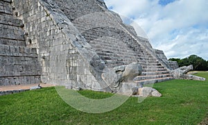 Feathered serpent at the base of the stairs of the El Castillo Pyramid at at Chichen Itza archeological site, Mexico.