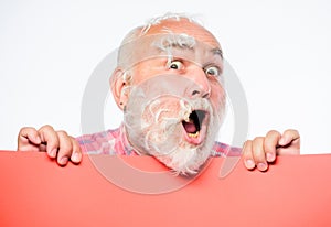 Feathers madness. Man bearded mature emotional face with stuck white feathers close up. Funny pensioner going crazy