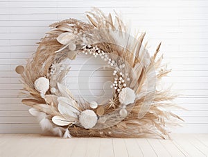 A feathery Christmas wreath with silvered pine sprigs and honesty on white plank wood background.