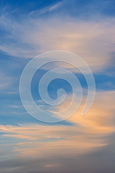 Feathery cirrus clouds at sunset on blue sky background