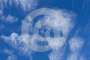 Feathery clouds in the blue sky. Light cirrus clouds against the blue sky