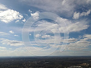 Feathery clouds that look painted in the deep blue sky shot from a high angle