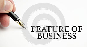 FEATURES OF BUSINESS the phrase on white paper and pen