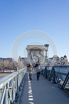 Feb 8, 2020 - Budapest, Hungary: Tourists on Szechenyi chain bridge in the morning
