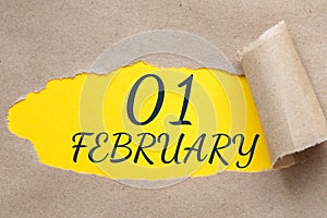 february 01. 01th day of the month, calendar date.Hole in paper with edges torn off. Yellow background is visible