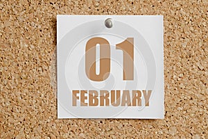 february 01. 01th day of the month, calendar date.White calendar sheet attached to brown cork board.Winter month, day of