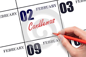 February 2. Hand writing text Candlemas on calendar date. Save the date.
