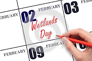 February 2. Hand writing text Wetlands Day on calendar date. Save the date.
