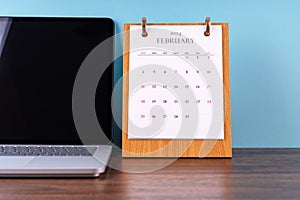 February 2024 desk calendar and laptop