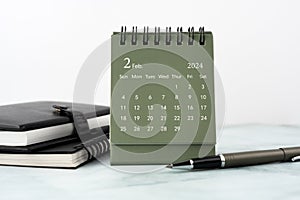 February 2024 desk calendar on top of table