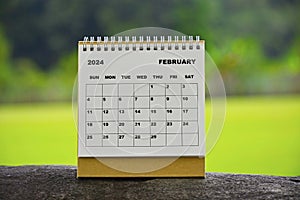 February 2024 white calendar with green blurred background.