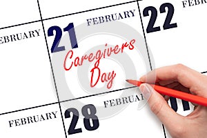 February 21. Hand writing text Caregivers Day on calendar date. Save the date.