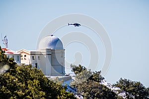 February 27, 2018 San Jose / CA / USA - Fox 2 News helicopter hovers above Lick observatory situated on top of Mt Hamilton on a