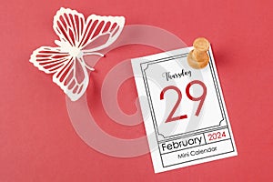 February 29th mini calendar for February 29 and wooden push pin on red background