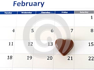 February calendar page with a heart chocolate marking valentines day