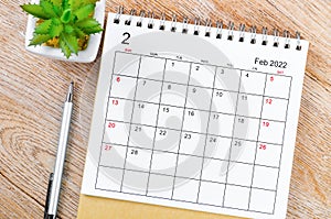 February 2022 desk calendar on wooden table photo