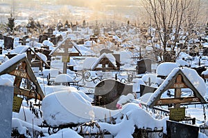 Crosses in a cemetery, monuments of the dead, a cemetery in winter, wreaths, artificial flowers. Russia