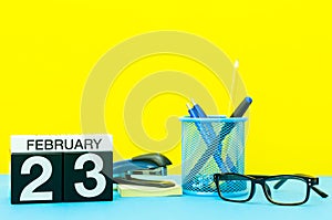 February 23rd. Day 23 of february month, calendar on yellow background with office supplies. Winter time