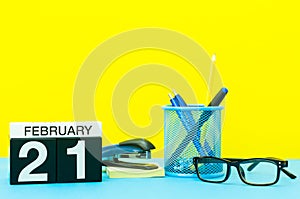 February 21st. Day 21 of february month, calendar on yellow background with office supplies. Winter time