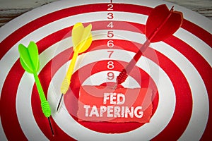 FED TAPERING. Piece of red paper and darts on the target